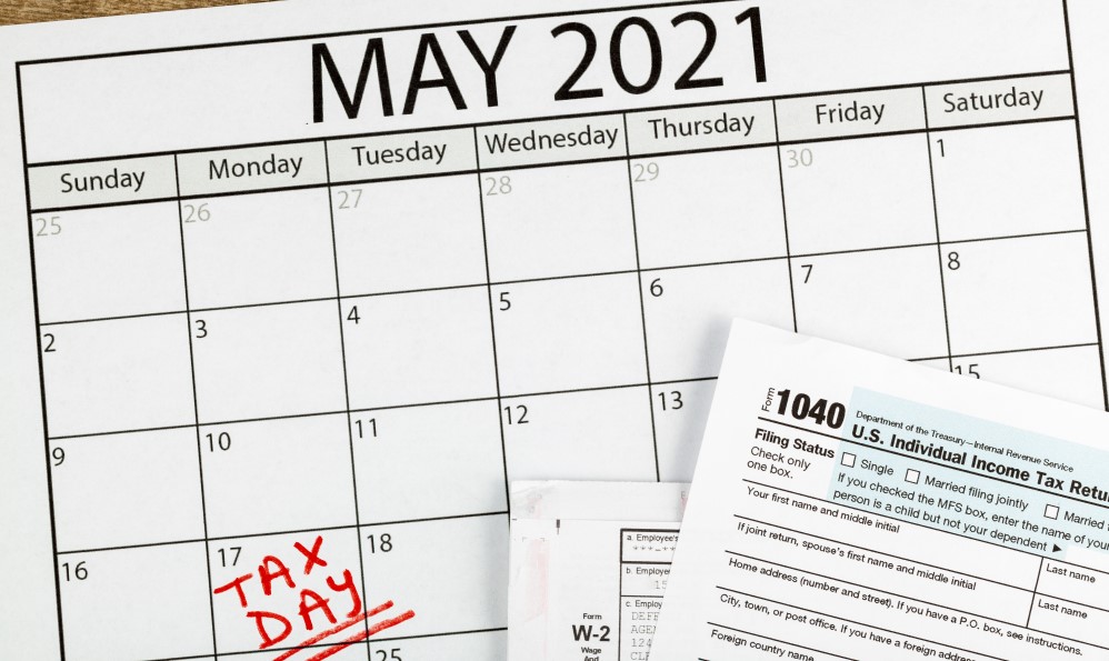 2021 Tax Day postponed - Picture of May Calendar with Tax Day written on May 17th and part of 1040 Federal Income Tax form